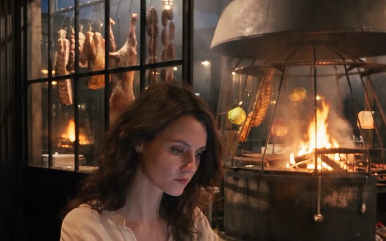 A diner looks at her phone at the table, with the hearth burning behind